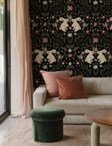 Dark botanical bunny wallpaper in modern bohemian, terracotta, rust, and green living room.